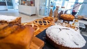 Mostrador de una panadería con diferentes productos horneados, incluyendo tartas y pasteles, en un entorno comercial.