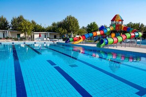 Ein Schwimmbad mit farbigem Wasserrutschen und einer Spielanlage.