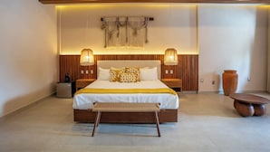 Une chambre à coucher moderne avec un grand lit, une tête de lit en bois, des lampes de chevet, une table de chevet et un grand vase.