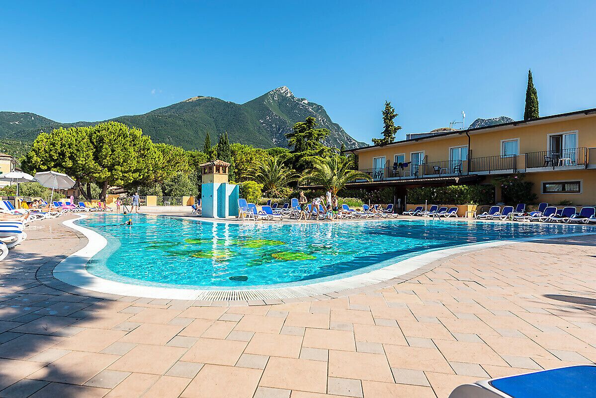 Ein Schwimmbecken mit Liegestühlen und Blick auf die Berge.