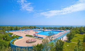 Ein Resort mit einem großen Pool, Liegestühlen und Meerblick.