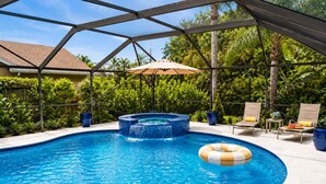 A swimming pool with a hot tub, lounge chairs, and an umbrella. - Beautiful Home with Sauna & Heated Pool-Spa, 5min from Beaches, close to Airport (Lantana)