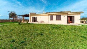 A single-story house with a patio, a small tree, and a clear blue sky. - Holiday Home 'Casa Del Sol' with Private Terrace, Wi-Fi and Air Conditioning (Andrano)