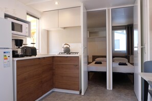 A compact kitchenette with a microwave, kettle, and coffee maker.