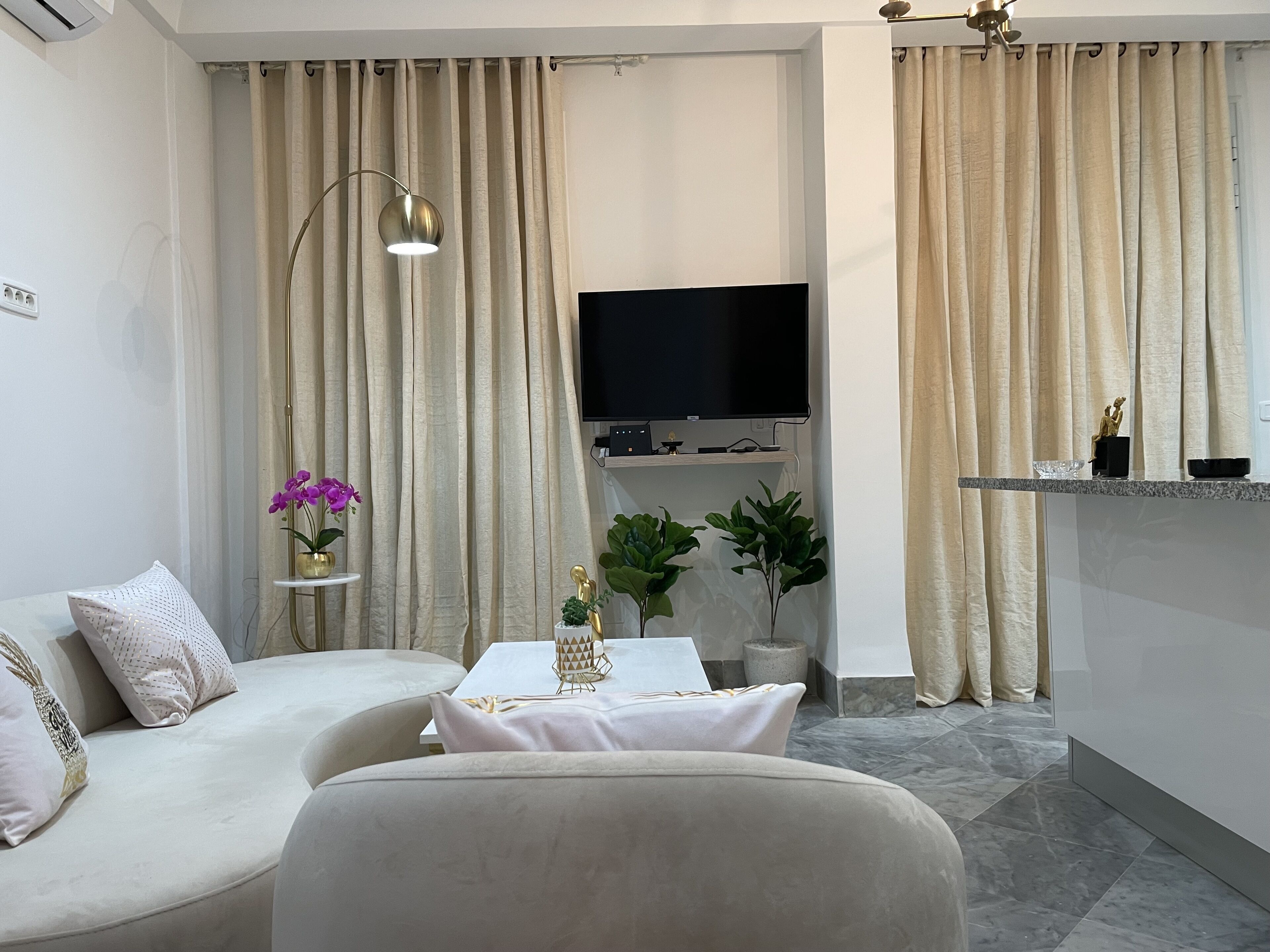 A modern living room with a sofa, a coffee table, and a flat-screen TV.