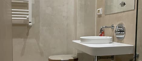 A modern bathroom with a toilet, sink, and shower.