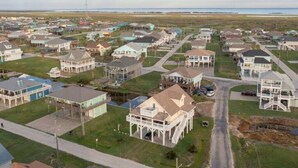 Et kystnært boligområde med huse, der har verandaer og udsigt til stranden.