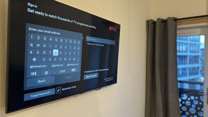 A flat-screen TV mounted on a wall displaying a sign-in interface for Netflix. -  Hull Spacious Apartment 7 (Hull)