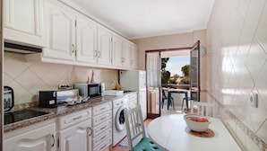 A compact kitchen with white cabinets, a microwave, toaster, and a sink. - Apartment 'Tenis Golfmar' with Shared Pool, Wi-Fi and Air Conditioning (Vialmoura)