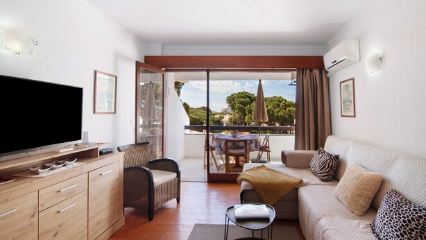 A living room with a television, sofa, and dining area with a table and chairs. - Apartment 'Tenis Golfmar' with Shared Pool, Wi-Fi and Air Conditioning (Vialmoura)