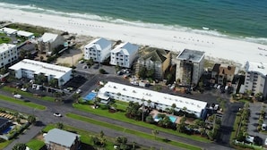 An aerial view of a coastal hotel with multiple buildings, a beach, and a parking area. - Beachside Getaway on Emerald Coast (Fort Walton Beach)