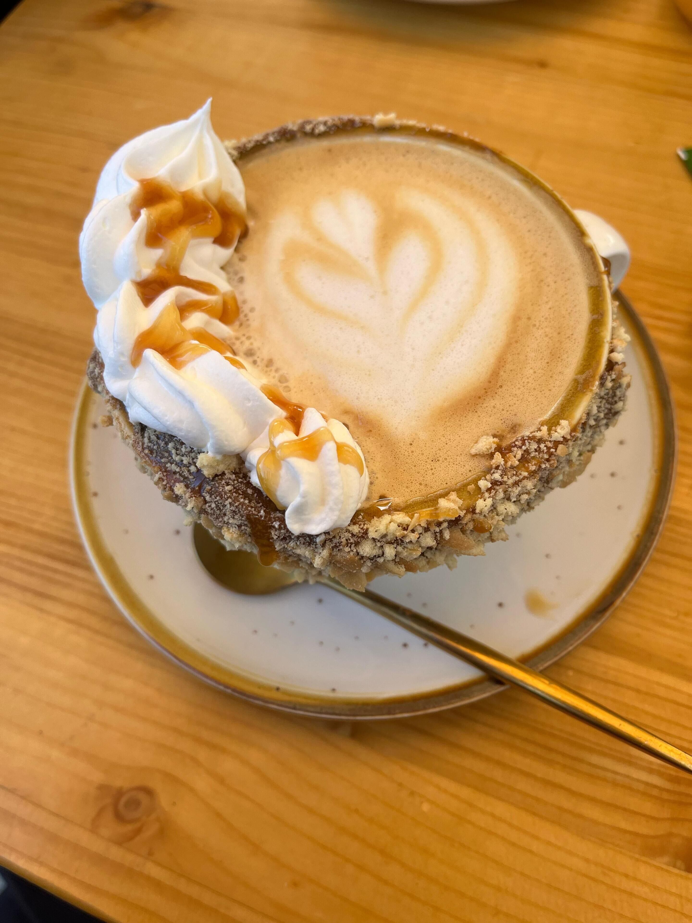 Annoksessa on kermavaahtoa ja päälle on valutettu karamellikastiketta.