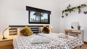Une chambre à coucher avec un lit, des tables de chevet, une fenêtre et une commode.