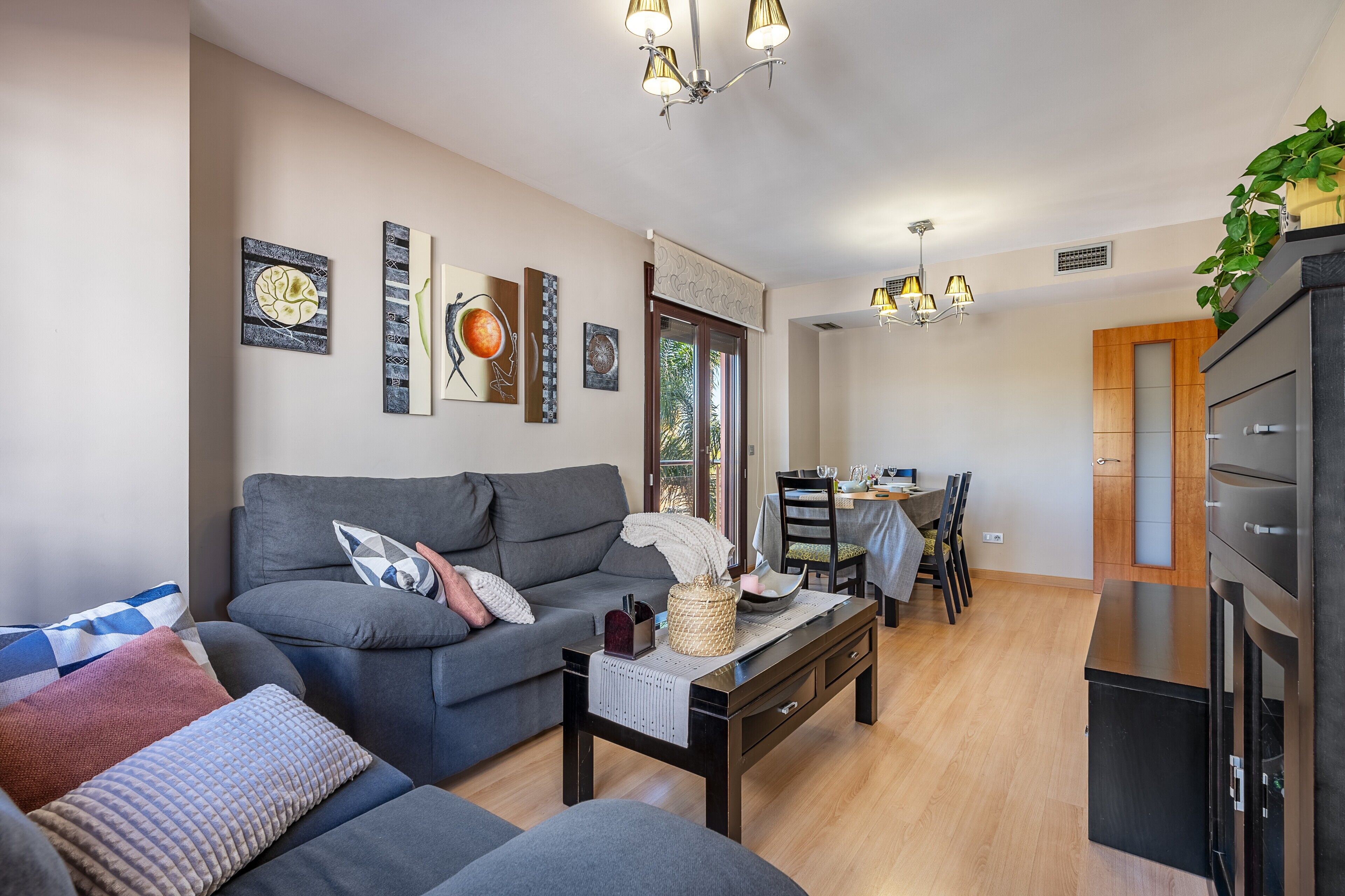 A living room with a sofa, coffee table, and artwork on the wall.