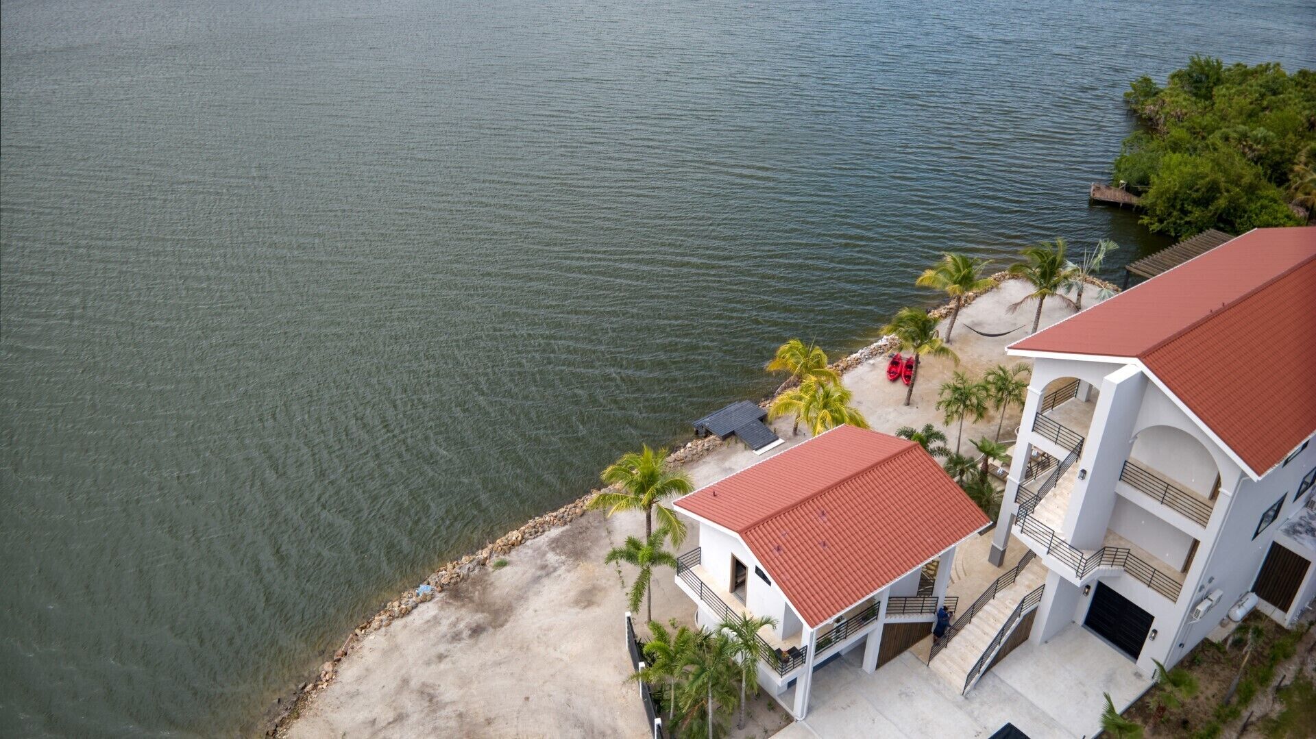 Ein Küstenhaus mit rotem Dach, einem Balkon und Blick auf das Meer.