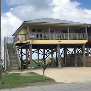 A two-story house with a balcony, a staircase leading to the upper floor, and a garage.