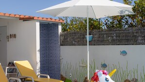 A swimming pool with inflatable unicorn and swan floats, a white umbrella, and sun loungers. - Bambus House Holidays Rental (Loulé)