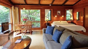 Eine Holzhütte mit Essbereich, zwei Betten und einer Couch.