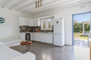 A modern kitchen with white cabinets, a built-in oven, and a window.