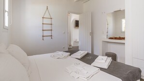 Ein Hotelzimmer mit einem Bett, einer Massageliege, einer Leiter, einem Spiegel und einem kleinen Hocker.