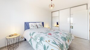 A bedroom with a bed, bedside table, and a hanging light fixture. - Amazing home in Landévant with WiFi (Landévant)