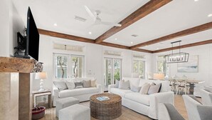 A spacious living room with white sofas, a round wicker coffee table, and a dining area with a table and chairs. - STEPS to Camp WaterColor! 6-Seater LSV/Golf Cart, 4 Bikes Included! (Santa Rosa Beach)