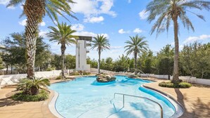 A swimming pool with a curved edge, surrounded by palm trees and lounge chairs. - 6-Seater LSV, 4 Bikes, Highland Park Stunner! Community Pool & Hot Tub! (Santa Rosa Beach)