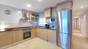 A modern kitchen with stainless steel appliances, wooden cabinets, and a tiled backsplash. - 2 bedroom nice apartment in Moncofa (Moncofa)