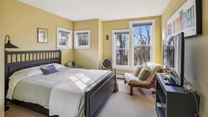 A bedroom with a bed, a chair, a desk, and a TV. - Cody's Clubhouse: 3 br, wood fireplace, firepit & deck (Waterbury Center)