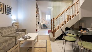 Un salon moderne avec un canapé, une table basse et un escalier menant à un autre niveau.