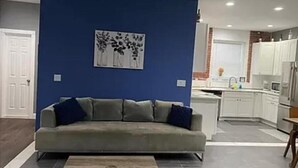 Ein modernes Wohnzimmer mit grauem Sofa, einem Couchtisch und einer blauen Akzentwand.