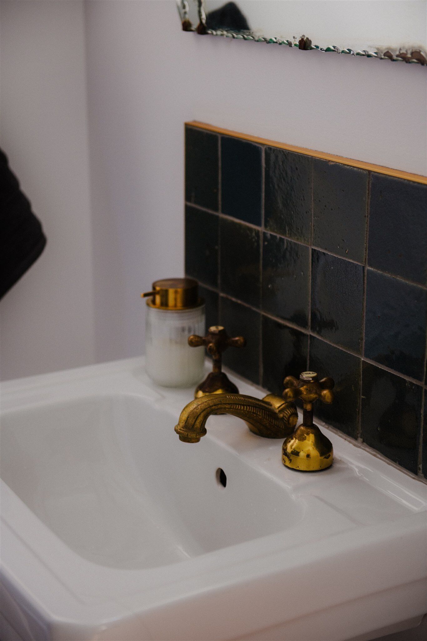 A bathroom sink with a white basin and a brass faucet.