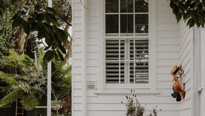 Una casa blanca con ventana, porche e hidrante.