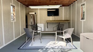 Una cocina moderna con un refrigerador empotrado, un microondas y un televisor de pantalla plana montado en la pared.