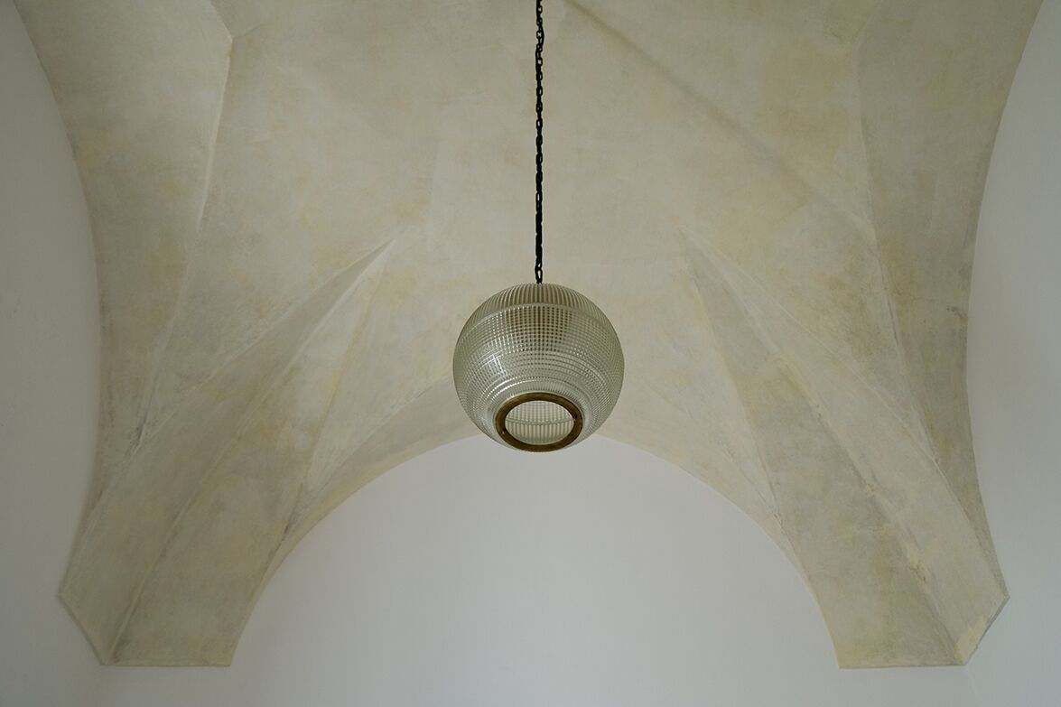 A hanging light fixture with a chain and a textured glass shade.