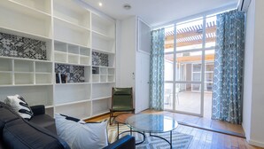 A modern living room with a sofa, a glass coffee table, and a bookshelf. - The Vella Apartment by Florit Flats (Valencia)