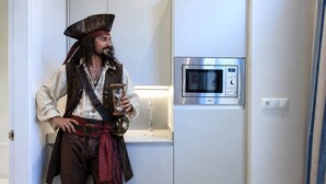 Una persona vestida de pirata en una habitación con microondas y lavabo.