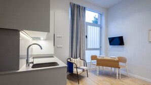A modern kitchen with a built-in sink and a dining area with a wooden table and chairs.