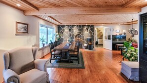 Un espacio habitable amplio con una mesa de comedor de madera, asientos cómodos, una chimenea de piedra y vistas a la cocina.