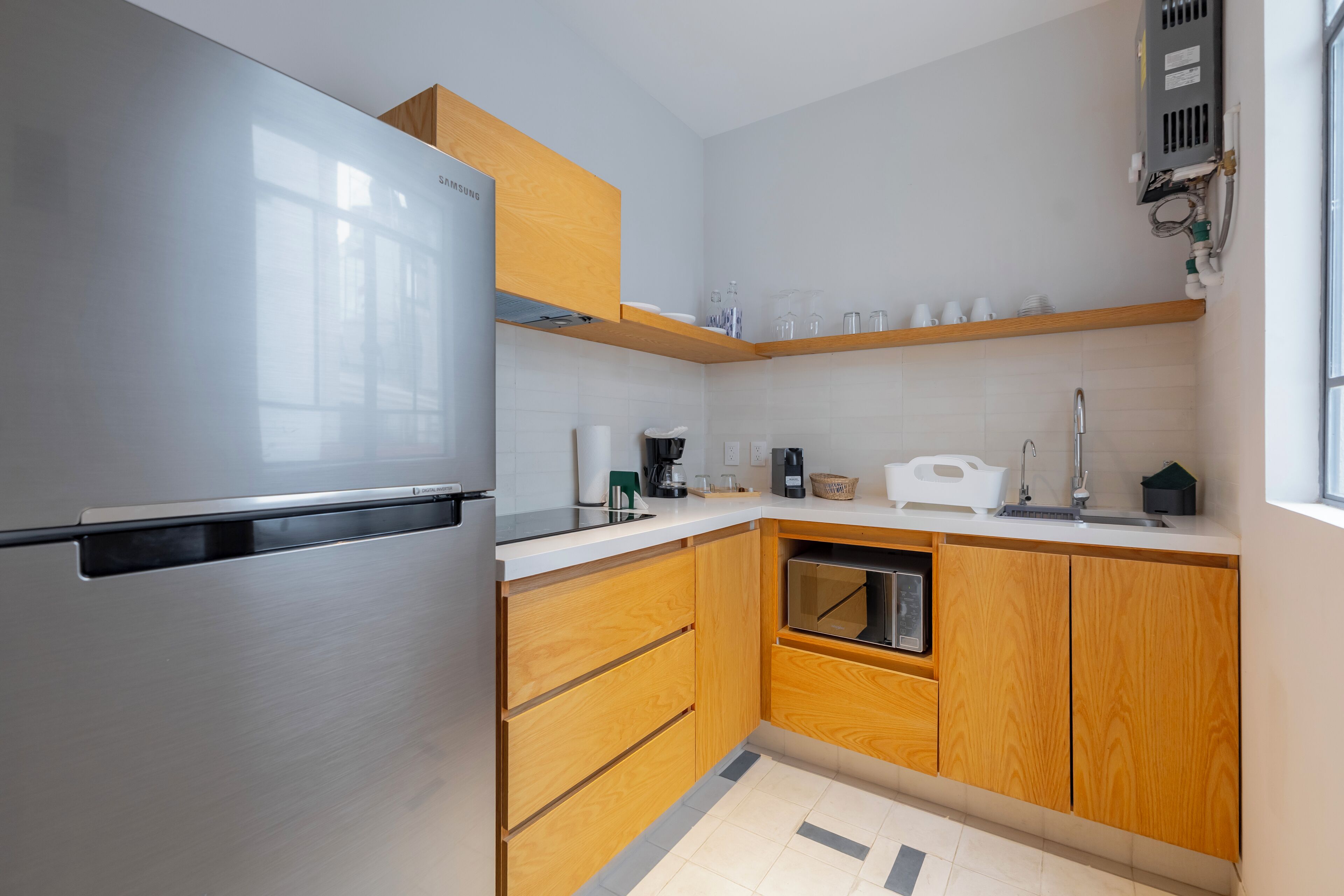 A modern kitchen with stainless steel appliances, wooden cabinets, and a built-in oven.