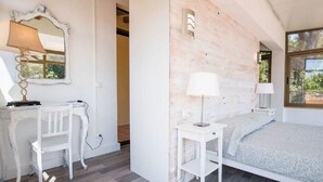 Ein Schlafzimmer mit Bett, Schreibtisch, Stuhl und Spiegel.