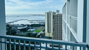 Un immeuble de grande hauteur offrant une vue sur une marina et un pont situé au loin.