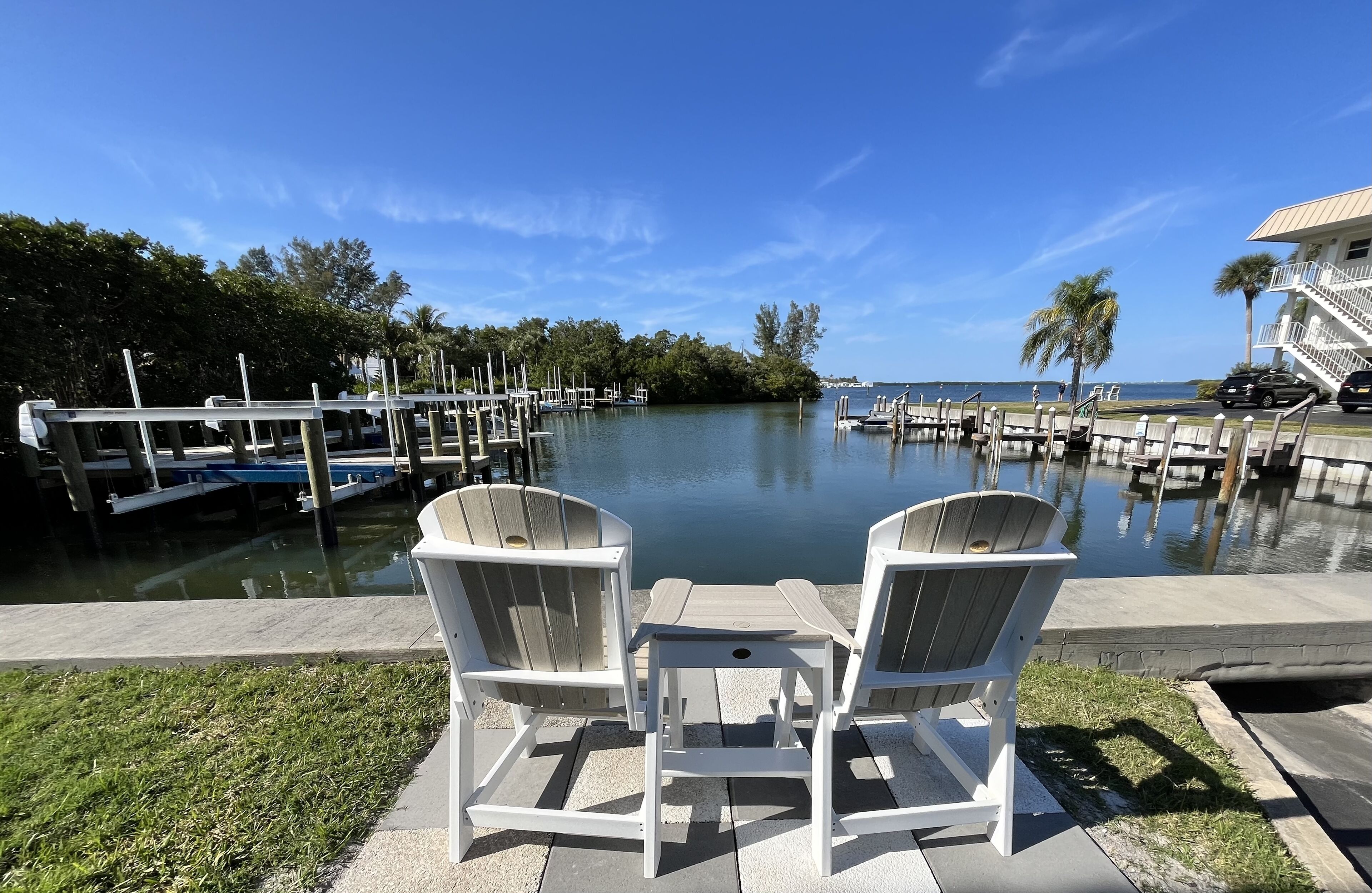 A marina with docked boats, a clear blue sky, and a view of the water.