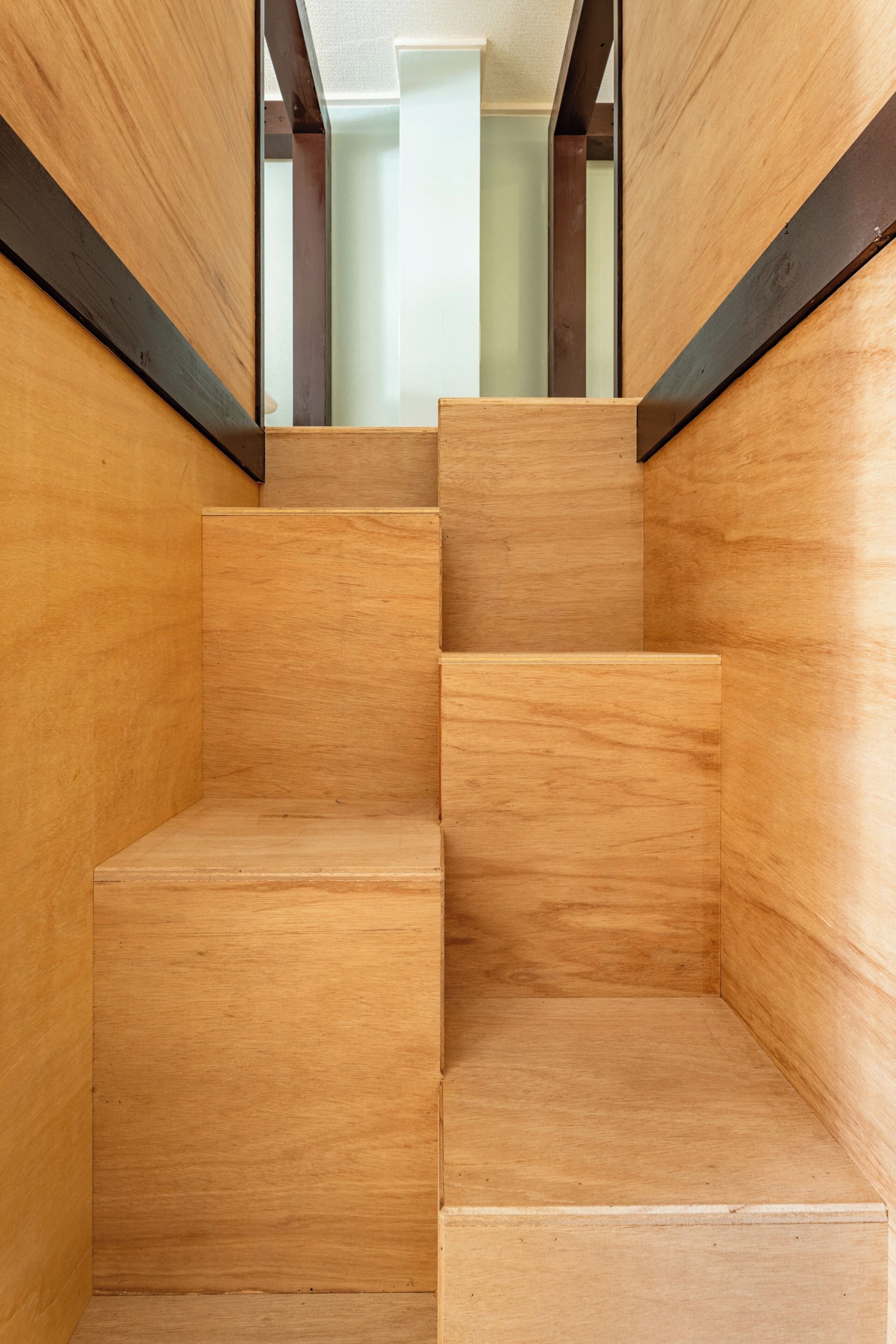 Un juego de escaleras de madera con un diseño minimalista, que conduce a un nivel superior.
