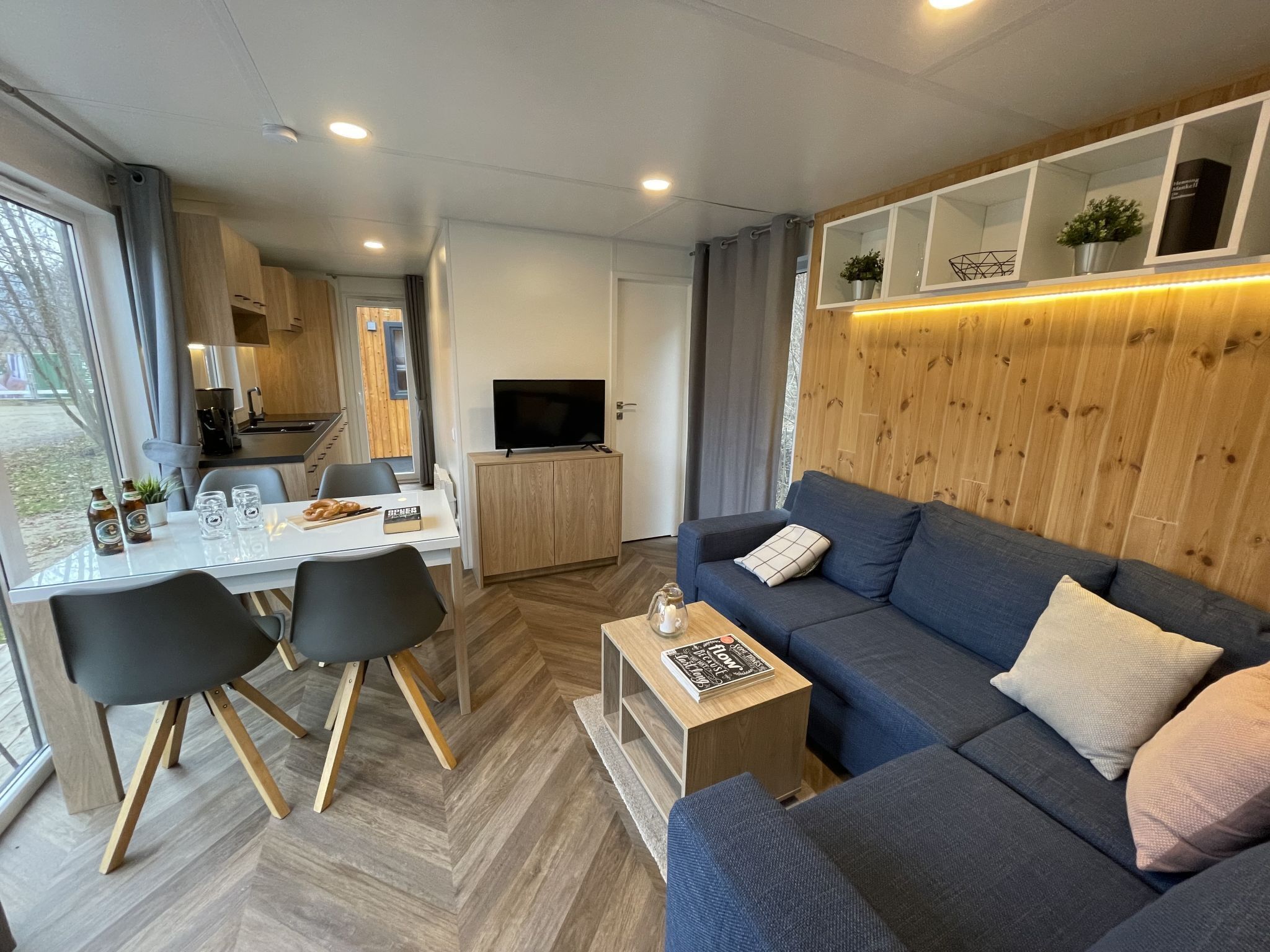 Ein modernes Wohnzimmer mit Sofa, Couchtisch und Essbereich.