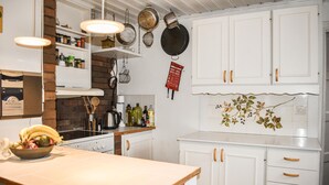 A kitchen with white cabinets, a wooden countertop, and hanging pots. - 2 bedroom nice home in Fjälkinge (Fjälkinge)