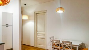 A small, well-lit room with a white door, a table with chairs, and a hanging light fixture. - 4 bedroom stunning apartment in Rijeka (Rijeka)