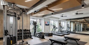 Een sportschool met gewichtmachines, loopbanden en dumbbells.