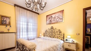 A bedroom with a bed, a nightstand, a radiator, a chandelier, and a painting on the wall. - Bellavista by Interhome (Acqui Terme)