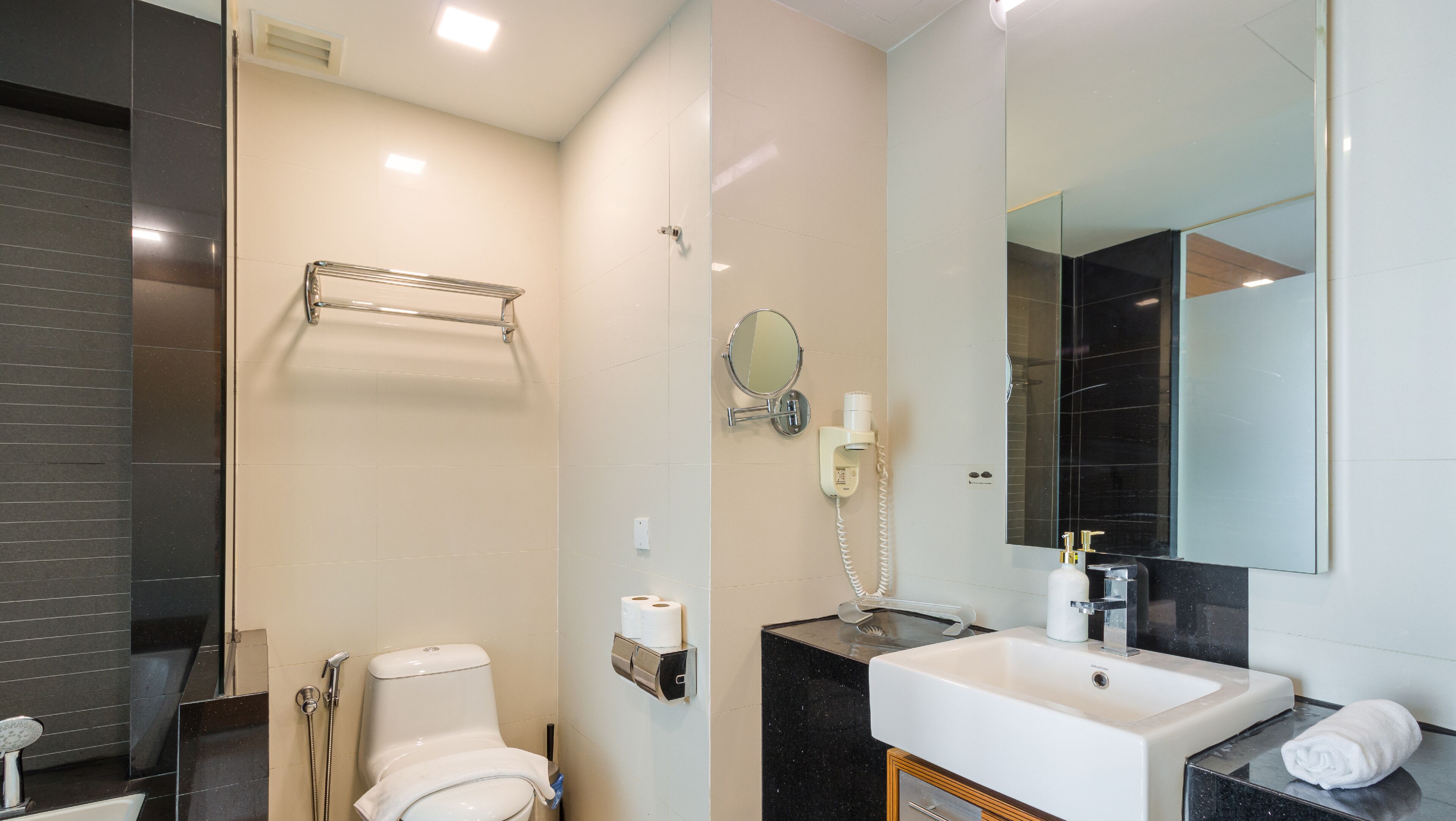 Une salle de bain moderne équipée de toilettes, d’un lavabo et d’une douche.